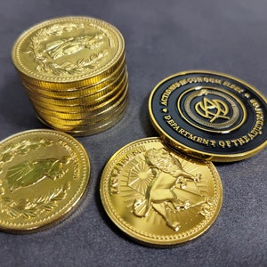 Puede incluir: Una pila de monedas de color dorado con un diseño de una persona con una corona y un león. También hay una moneda negra con letras doradas que dice "Action Squad, Department of the Bad Guys".