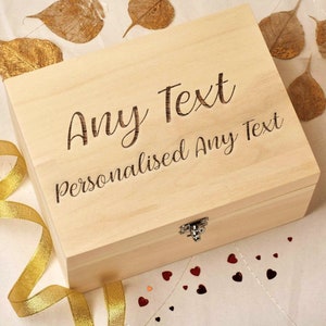 May include: A light wood box with a hinged lid and a silver latch. The box is engraved with the text "Any Text Personalised Any Text".
