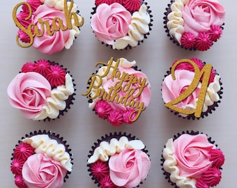 May include: Nine pink and white cupcakes with gold glitter decorations. The cupcakes are decorated with the words "Sarah", "Happy Birthday", and the number "21".
