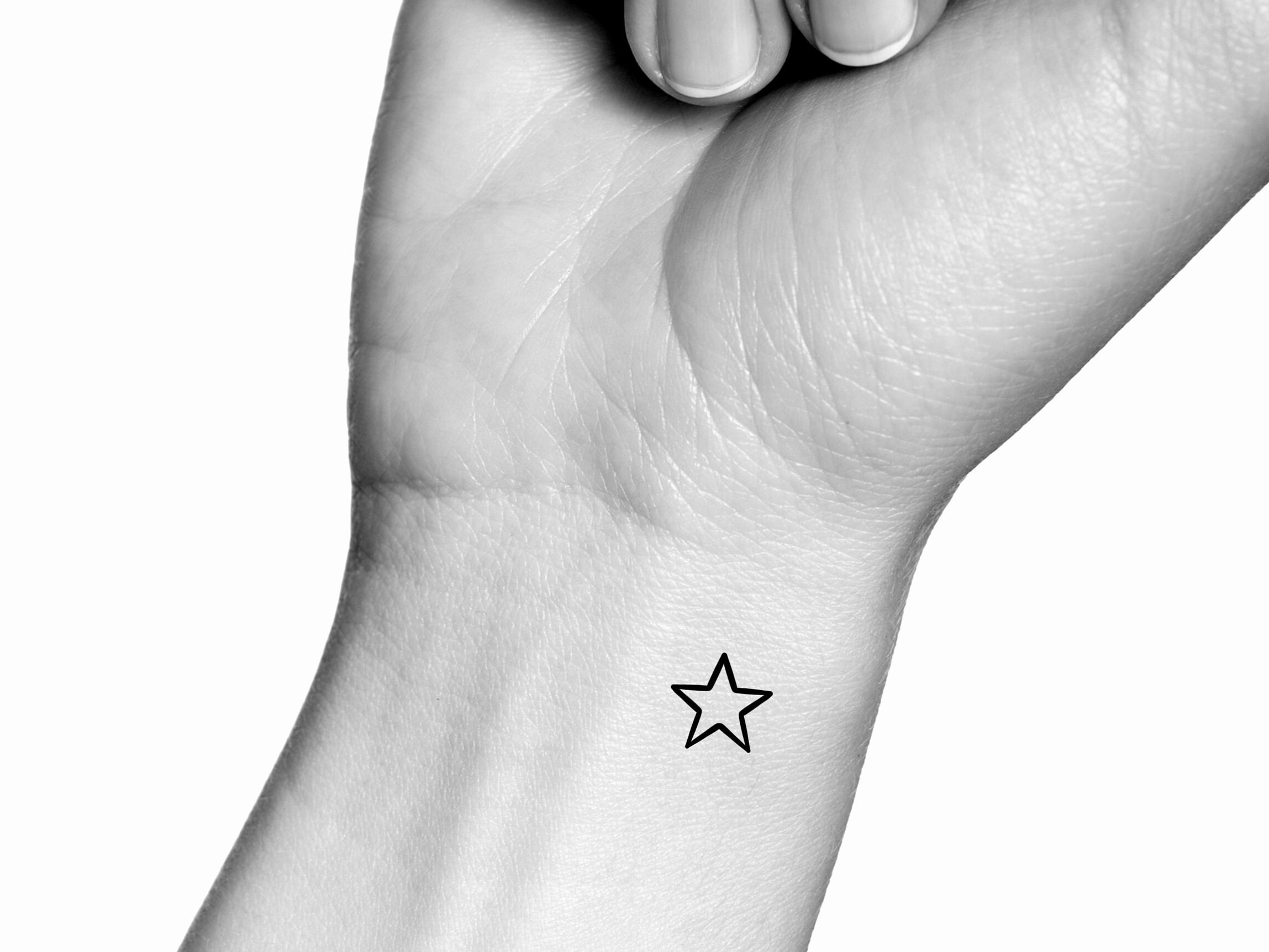 Star outline tattoo on the wrist