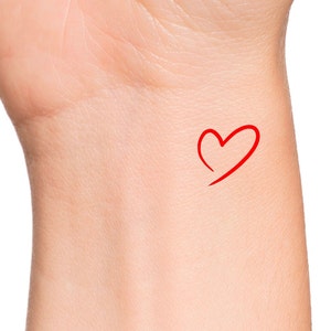 May include: A red heart drawn on a person's wrist.