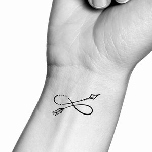 May include: A black infinity symbol tattoo on a person's wrist with an arrow going through it.