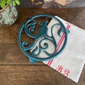 Antieke onderzetter, geëmailleerd gietijzer in Art Nouveau-stijl.