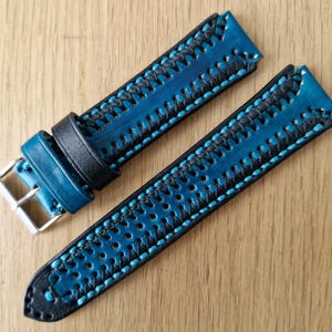 Könnte beinhalten: Ein blaues und schwarzes Lederarmband mit einem genähten Design. Das Armband hat eine Schließe und ist aus hochwertigem Leder gefertigt.