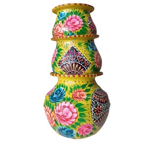 May include: A decorative, hand-painted yellow pot with a floral design. The pot is stacked and features pink, blue, and white flowers with green leaves. The pot has a unique shape and is likely for home decor.