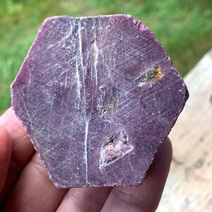 Basal hexagonal face raw ruby crystal, clear growth lines and triangular pit, red corundum specimen, July birthstone.