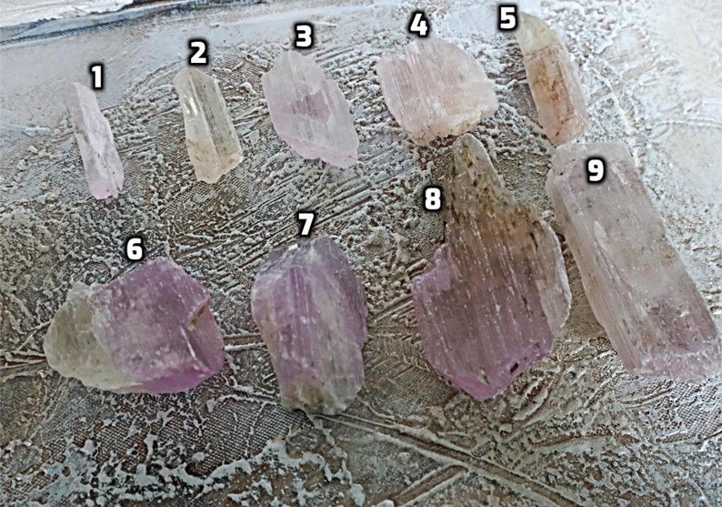 May include: Nine pink and clear crystal specimens of varying sizes and shapes. The crystals are numbered 1 through 9.