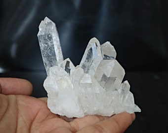 May include: A cluster of clear quartz crystals with a variety of sizes and shapes. The crystals are arranged in a natural formation, creating a unique and beautiful display.