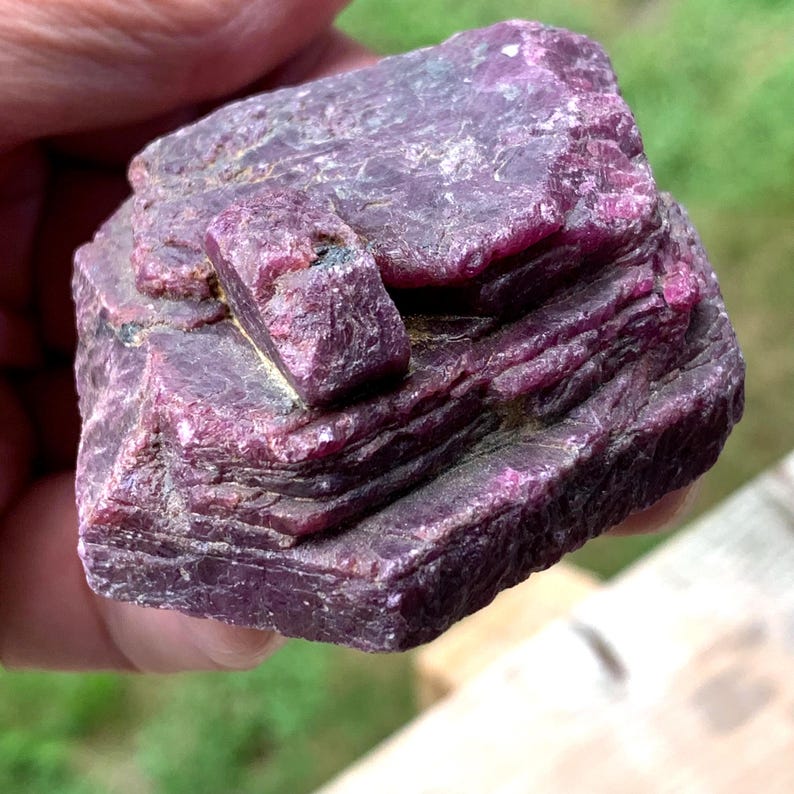 Oblique view raw ruby crystal, small perched crystal and ridged, striated sides, Indian ruby specimen.