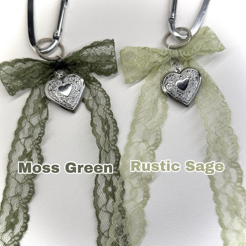 Peut inclure: Deux porte-cl&eacute;s avec des rubans en dentelle et des m&eacute;daillons en forme de c&oelig;ur. L'un a un ruban vert mousse, l'autre un ruban vert sauge. Le texte "Moss Green" et "Rustic Sage" est imprim&eacute; en dessous.