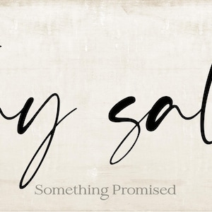 May include: A rectangular wooden sign with the words "stay salty" in black cursive script. The phrase "Something Promised" is written in a smaller, gray font below the main text. The background has a light, textured appearance.