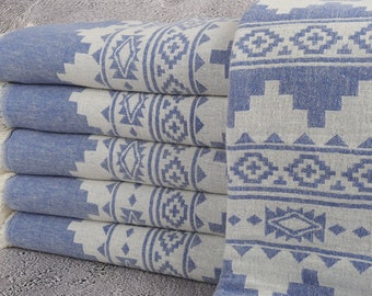 May include: A stack of blue and white patterned towels. The towels have a geometric design in white against a blue background. The edges of the towels have a fringe.