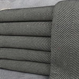 May include: A stack of black and white striped towels with fringe edges. The towels are folded and arranged in a herringbone pattern.