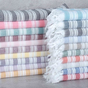 May include: A stack of striped towels in various colors, including navy blue, bright pink, petrol green, burgundy, powder pink, damson, yellow, purple, lilac, mustard, turquoise, petrol blue, baby blue, brown, dark green, orange, light gray, sax blue, and red.