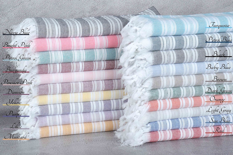 May include: A stack of striped towels in various colors, including navy blue, bright pink, petrol green, burgundy, powder pink, damson, yellow, purple, lilac, mustard, turquoise, petrol blue, baby blue, brown, dark green, orange, light gray, sax blue, and red.