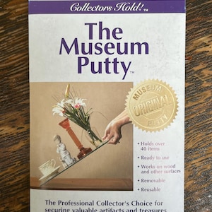 May include: A package of The Museum Putty, a professional collector's choice for securing valuable artifacts and treasures from breakage. The putty is ready to use, removable, and reusable. It holds over 40 items and works on wood and other surfaces. The package is white with gold lettering and a gold seal that says "Museum Original Putty".