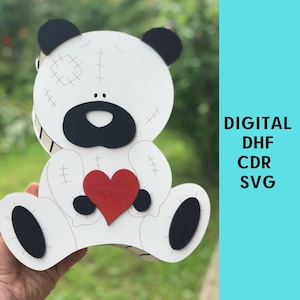 May include: White teddy bear with black eyes, nose, and feet holding a red heart. The bear has stitched details on its body. DIGITAL DHF CDR SVG.