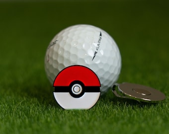 May include: A white golf ball with the text "Pro V1x" printed on it, a red and white Pokeball golf ball marker, and a silver golf ball retriever.
