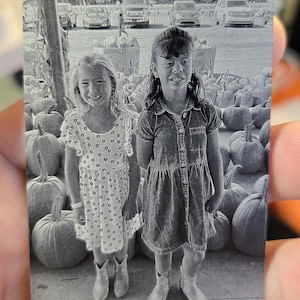 May include: A grayscale card with the text "Human Citizen" at the top. The card features two young girls standing in front of pumpkins. The bottom right corner has the number "1/1".