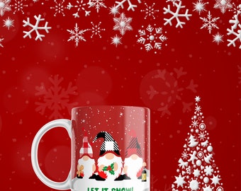 May include: White ceramic mug with a festive design featuring three gnomes with red and black plaid hats, holding holly and a lantern, against a red snowy background. The mug has the text "LET IT SNOW!"