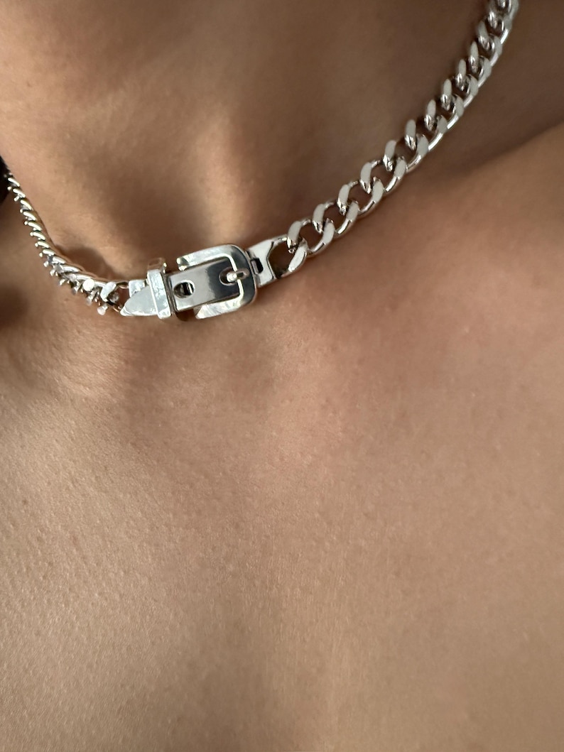 Extreme close-up of the adjustable belt buckle detail on a silver Cuban link chain, showing the high-quality 1-micron silver plating