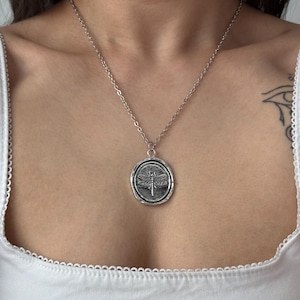 silver tone dragon fly pendnat necklace on girl’s chest