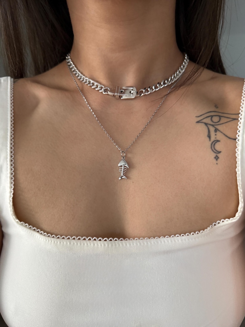 Two silver necklaces layered together, featuring the signature belt buckle Cuban choker as the base statement piece.