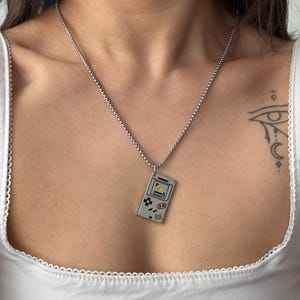 May include: A set of three ceramic mugs with a speckled, matte finish in cream, light grey, and dark grey. Each mug has a simple, minimalist design, ideal for tea or coffee.