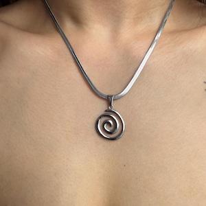 A wide lifestyle view of the adjustable 40cm silver snake chain with a spiral charm, emphasizing its versatile fit for everyday edgy outfits.