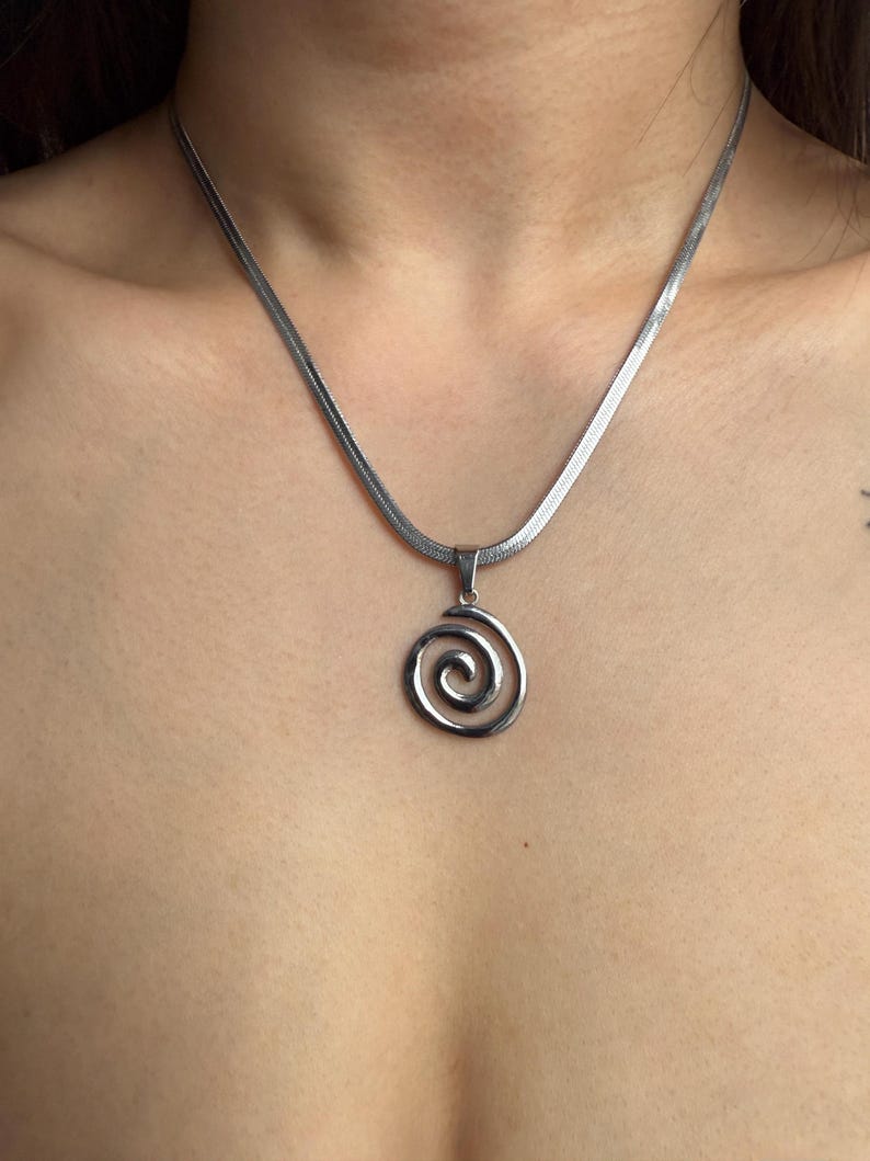 A wide lifestyle view of the adjustable 40cm silver snake chain with a spiral charm, emphasizing its versatile fit for everyday edgy outfits.