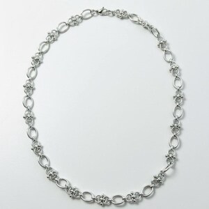 Overhead studio shot of a 60cm long industrial hardware-style necklace, showing the substantial 12mm width and secure lobster clasp closure.