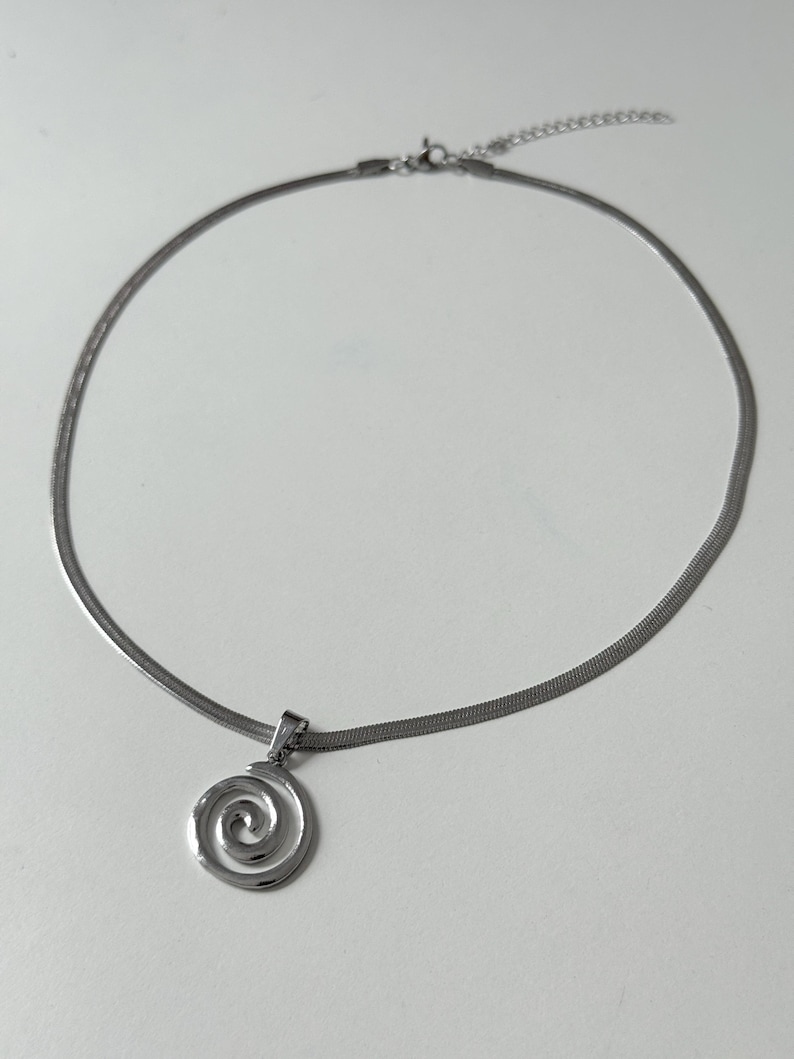 The entire spiral necklace laid out in a circle on a white background, clearly showing the lobster claw clasp and 5cm extender.