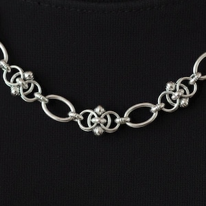 Extreme close-up of the stainless steel pierced jewelry links, detailing the high-quality craftsmanship and rugged industrial aesthetic of the chainmail weave.