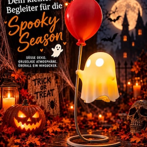 Könnte beinhalten: Eine weiße geisterförmige Lampe mit zwei runden Augen, die einen dünnen Stab mit einem roten Ballon hält. Die Lampe zeigt den Text: "Dein kleiner Begleiter für die Spooky Season", "SÜSSE DEKO. GRUSELIGE ATMOSPHÄRE. ÜBERALL EIN HINGUCKER." und "TRICK OR TREAT".