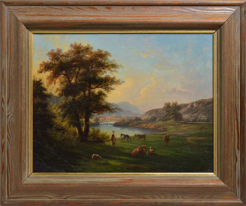 Op de afbeelding: Een schilderij dat een landelijk landschap afbeeldt met een grote boom op de voorgrond, een rivier die door de sc&egrave;ne slingert en een groep koeien die grazen in een weiland. De lucht is zachtblauw met hints van roze en oranje, wat suggereert dat het zonsondergang of zonsopgang is.
