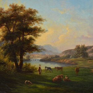 Op de afbeelding: Een schilderij van een landelijk landschap met een grote boom op de voorgrond, een rivier en een dorp in de verte. Er grazen koeien en schapen in het veld, en een vrouw staat bij de rivier.