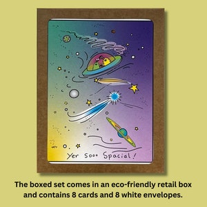 Peut inclure: Un ensemble de 8 cartes de vœux sur le thème de l'espace. Les cartes présentent une illustration colorée d'un vaisseau spatial, d'étoiles et de planètes. Le texte sur la carte est "Yer Sooo Spacial !"