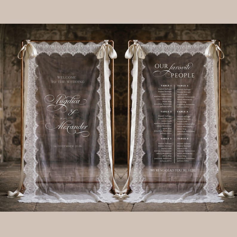 May include: Two rectangular clear acrylic wedding signs framed in copper, draped with white lace fabric and tied with white ribbons. The left sign reads Welcome to the Wedding, Angelica & Alexander, 14 December 2026. The right sign reads Our Favorite People.