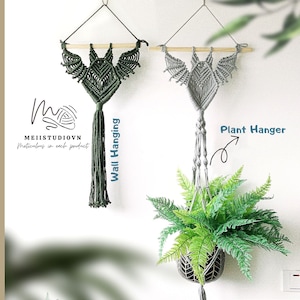 May include: Two macrame wall hangings, one green and one gray. The gray hanging is used as a plant hanger with a green fern plant in it. The text "Plant Hanger" is written on the image. The text "Wall Hanging" is written on the image. The text "Macrame art by Meii" is written on the image.