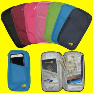 May include: A set of travel wallets in various colors, including black, burgundy, pink, green, blue, and navy. The wallets have multiple pockets and a zipper closure. One wallet is open, showing a passport, cash, credit cards, and a pen.