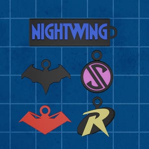 Puede incluir: Una colección de colgantes y llaveros con temática de superhéroes. Incluye una etiqueta Nightwing negra, un símbolo de murciélago negro, un emblema rosa y negro, un símbolo de murciélago rojo y un emblema amarillo y negro con la letra "R".