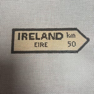 May include: A brown and black sign with the text "IRELAND EIRE" and "km 50".