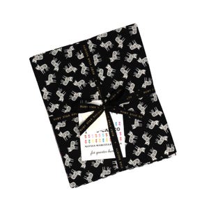 Peut inclure: Un lot de tissu avec un fond noir et un motif de tigre blanc répété. Le lot est noué avec un ruban noir et comprend une étiquette. Le tissu est de la Ruby Star Society.