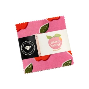 May include: A stack of 42 fabric squares measuring 2.5 inches each, featuring a pink background with red apple shapes and green leaves. A paper band wraps around the center with the text Ruby Star Society and Sparkle Shopper by Melody Miller.