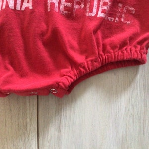 May include: Red baby onesie with white text that reads "California Republic".