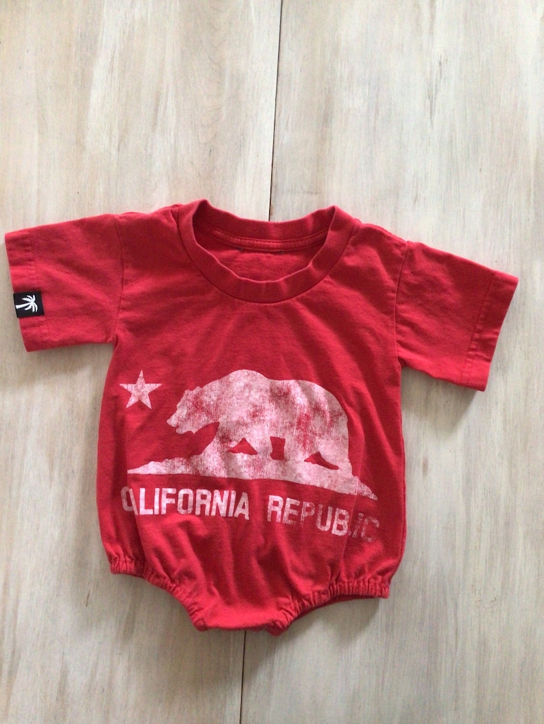 May include: Red baby onesie with a white graphic of the California bear and the text "CALIFORNIA REPUBLIC".