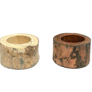 May include: Two wooden candle holders, one is natural wood and the other is stained a reddish brown colour.