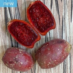 Puede incluir: Cuatro frutos de chumbera, tres de los cuales están cortados por la mitad para revelar su pulpa roja brillante. La fruta es de un color rojo vibrante con una piel texturizada y moteada.