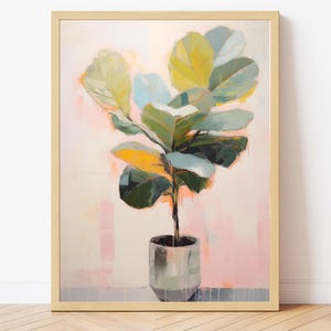 May include: Abstract painting of a fiddle-leaf fig plant in a silver pot. The plant has large green, yellow, and blue leaves. The background is a soft pink with vertical strokes of colour. The artwork is framed in a light wood frame.