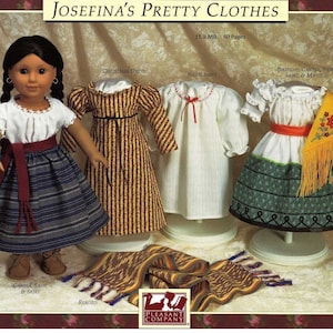 May include: A set of doll clothes for a 18-inch doll, including a white nightgown, a yellow and brown striped dress, a white blouse with a green and white skirt, and a red sash. The doll clothes are displayed on mannequins. The image also includes a brown, yellow, and red woven shawl.